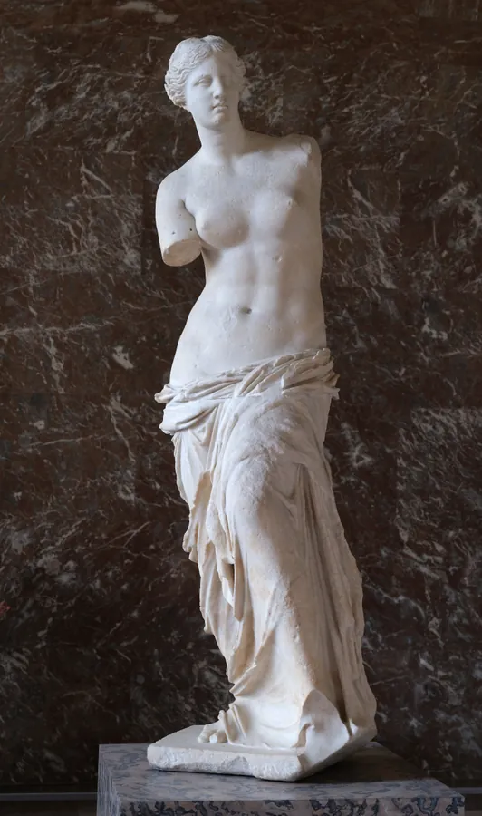Photographie d’archive de la version précédente : statue de marbre de la Vénus de Milo, sans bras, drapée à partir des hanches.